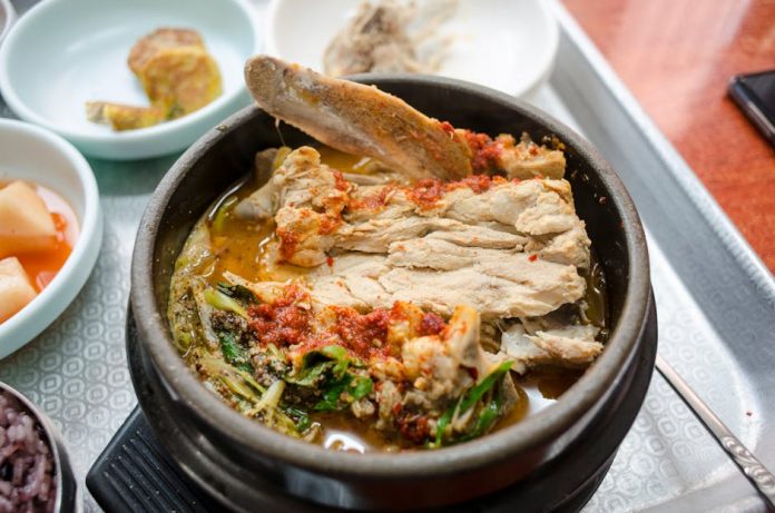 customized hmr korean meal kits trend - Delicious Korean stew with pork rib and fresh vegetables in a clay pot, showcasing vibrant traditional flavors.