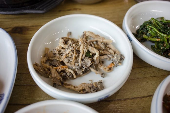 one bowl korean solo dining trend - A delicious assortment of traditional Korean banchan side dishes served in ceramic bowls.